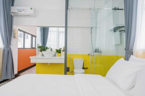 a bedroom with a bed and a shower and a toilet at Cosy Hotel in Ho Chi Minh City
