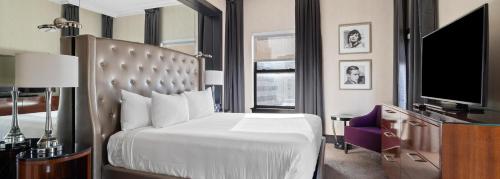 a hotel room with a bed and a tv at Hotel De Anza in San Jose