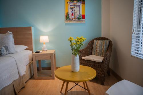 a small room with a table and a vase with flowers at Posada La Fe in Cartagena de Indias
