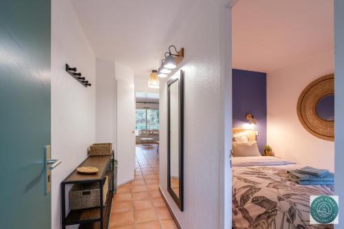 une chambre avec un lit et un miroir dans l'établissement Les Pins dorés le petit nid douillet et cosy, à Soustons