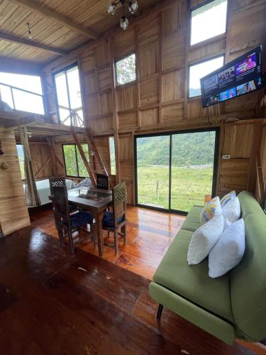 a living room with a green couch and a table at Villa Elena Sumaco in San Francisco de Borja