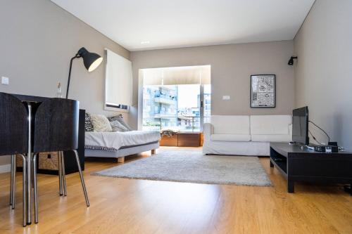 a living room with a white couch and a table at Póvoa Beach Apartment in Póvoa de Varzim