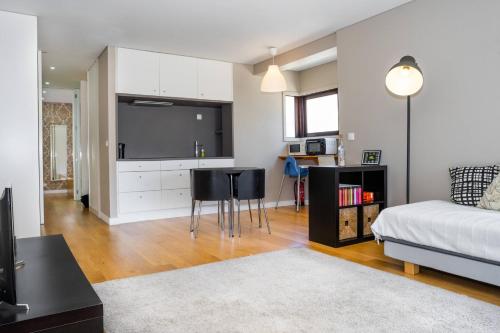 a living room with a bed and a kitchen at Póvoa Beach Apartment in Póvoa de Varzim