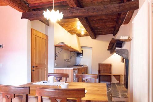 a kitchen and dining room with a wooden table and chairs at Antica Casa Rivoira Ciliegio in Masera