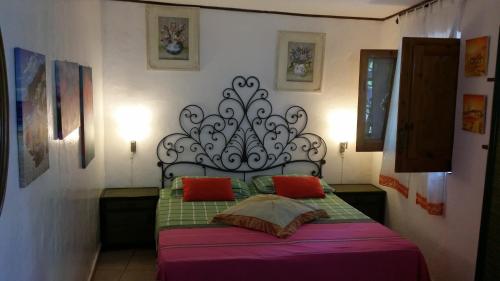 a bedroom with a bed with a black headboard and red pillows at Aquilone Residence in Stromboli