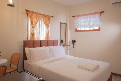 a bedroom with a large white bed with a window at JB Home Bangkok - Victory monument in Bangkok