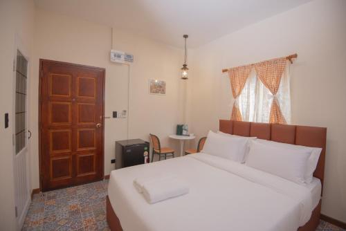 a bedroom with a bed and a wooden door at JB Home Bangkok - Victory monument in Bangkok