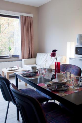 a dining room table and chairs with a table and a couch at Budget Flats Brussels in Brussels
