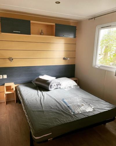une chambre avec un lit dans une pièce avec une fenêtre dans l'établissement MH tout confort 2ch 5pers 600HM, à La Boissière-de-Montaigu
