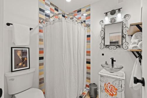 a bathroom with a white shower curtain and a sink at Little Henry House on Duke St in Portland