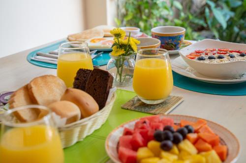 a breakfast table with breakfast foods and orange juice at Posada La Fe in Cartagena de Indias