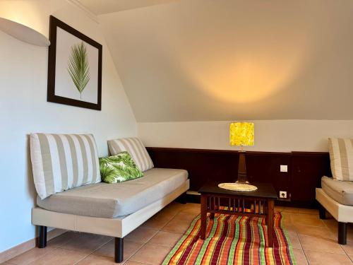 a living room with a couch and a table at Kaz Caraïbes spacieuse, accès piscine et plage - Résidence in Sainte-Luce