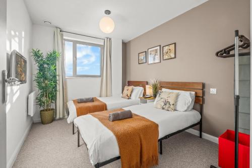 a bedroom with two beds and a window at Pan Asian Haven with Balcony with CityView and Free Parking in Birmingham