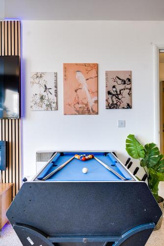 a pool table in a room with paintings on the wall at Pan Asian Haven with Balcony with CityView and Free Parking in Birmingham