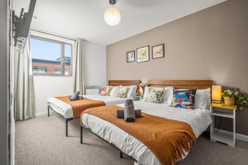 a bedroom with two beds and a window at Pan Asian Haven with Balcony with CityView and Free Parking in Birmingham