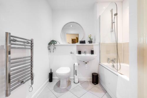 a white bathroom with a toilet and a sink at Pan Asian Haven with Balcony with CityView and Free Parking in Birmingham