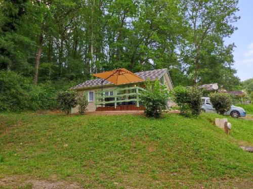 une maison avec un parasol dans une cour dans l'établissement Chalet 31, à Le Mas