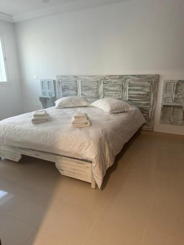 een slaapkamer met een groot bed met twee handdoeken erop bij Les portes délavées in Sfax