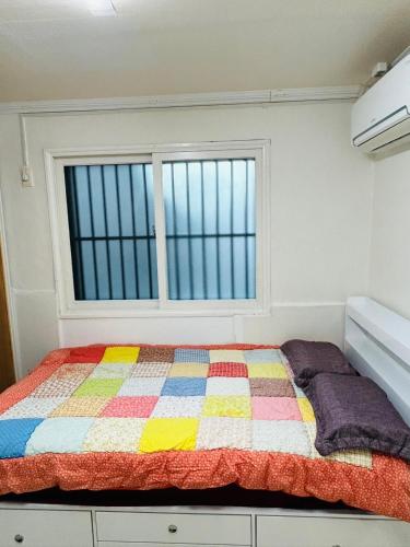 Ένα ή περισσότερα κρεβάτια σε δωμάτιο στο NJ Affordable and cozy accommodation near Nakseongdae Station