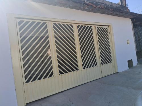 a wooden gate on a white garage door at Espaço Tranquilo-preço até 4 hóspedes in Pôrto Feliz