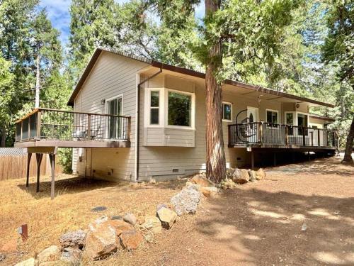 a house with a balcony and a tree at Family get away Near Sly Park Lake & Apple Hill in Pollock Pines