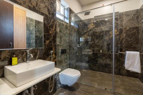 a bathroom with a sink toilet and a shower at ELIVAAS Jamun Farm 2BHK with Pool in Jaipur