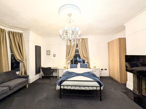 a bedroom with a bed and a table and a chandelier at Fulforth St Studio Apartments in Nottingham