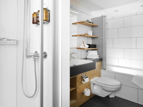 a bathroom with a shower and a toilet and a sink at Beausite Park Hotel & Spa in Wengen