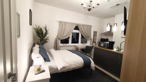 a bedroom with a bed and a desk and a window at Fulforth St Studio Apartments in Nottingham