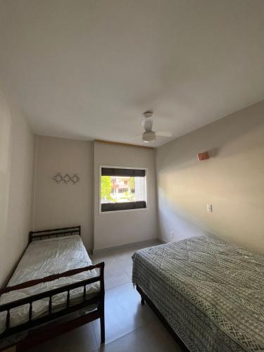 a bedroom with two beds and a window at Apartamento confortável na praça central in Águas de Lindoia