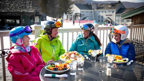 a group of people sitting at a table eating food at Disney Wonderland Suite at Jiminy-Ski On Off Mtn - Must See Stitch and Mickey Magic in Hancock