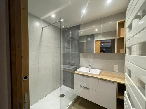 une salle de bain avec un lavabo et une douche en verre dans l'établissement Appartement rénové 2 pièces au pied des pistes - Exposé Sud-Ouest, balcon, animaux OK - FR-1-449-10, à Tignes