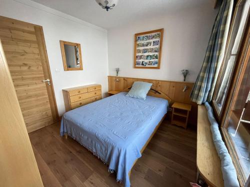 - une chambre avec un lit bleu et une porte dans l'établissement Appartement rénové 2 pièces au pied des pistes - Exposé Sud-Ouest, balcon, animaux OK - FR-1-449-10, à Tignes