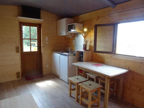- une cuisine avec un comptoir et une table dans une pièce dans l'établissement Belle roulotte de style chalet au coeur du Sancy, à La Tour-dʼAuvergne