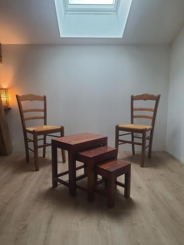 2 chaises, une table en bois et 2 chaises dans l'établissement La maison d'ô, à Frayssinet-le-Gélat