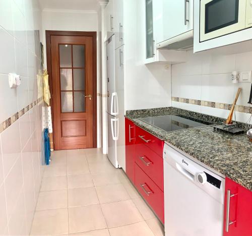 a kitchen with red cabinets and a red door at Apartamento en Gibaja in Gibaja