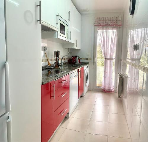 a kitchen with red cabinets and a washing machine at Apartamento en Gibaja in Gibaja