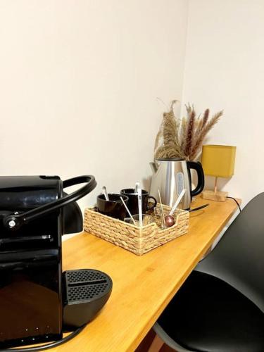 un panier en osier posé sur une table à côté d'un micro-ondes dans l'établissement Les chambres de la bastide - 201, à Carcassonne