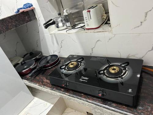 a stove top in a kitchen with pots and pans at Rumi HomeStays in Bhubaneshwar
