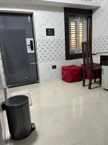 a living room with a trash can and a chair at Rumi HomeStays in Bhubaneshwar