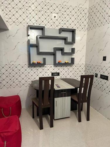 a table with two chairs and a mirror on a wall at Rumi HomeStays in Bhubaneshwar