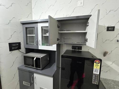 a kitchen with a microwave and a counter top at Rumi HomeStays in Bhubaneshwar