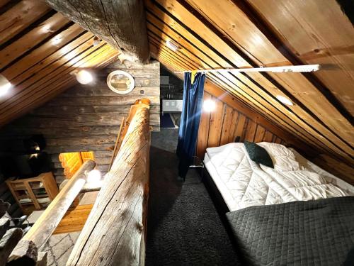 a room with two beds in a wooden cabin at Luosto Jylhäkelo - a cozy loghouse in the heart of Lapland in Luosto