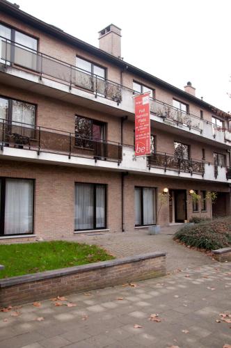 a large brick building with a sign in front of it at Budget Flats Brussels in Brussels