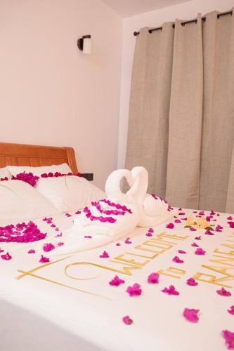 a bed with flowers on it with a swan on it at Rangali thoddoo Maldives in Thoddoo