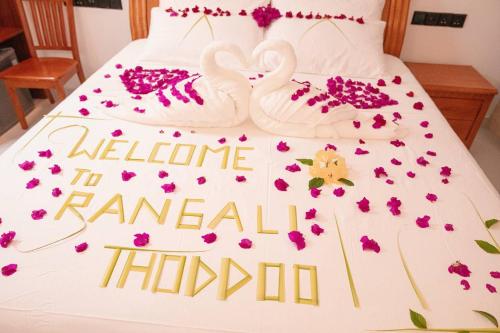 two white swans are on a bed with flowers at Rangali thoddoo Maldives in Thoddoo