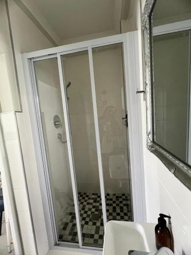 a glass shower door in a bathroom with at Charming Flatlet Near the Amazing Sunset Beach in Cape Town