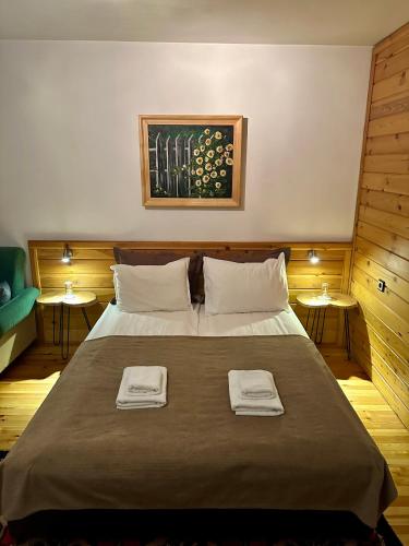 a bedroom with a large bed with two towels on it at Guest House Dzhangal in Bansko