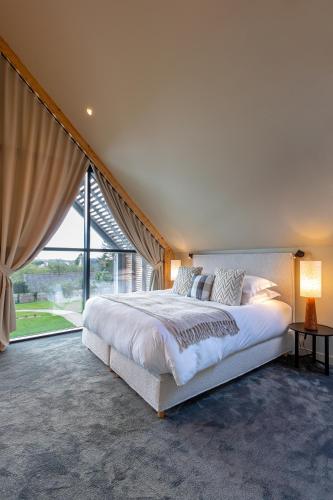 une chambre avec un grand lit et une grande fenêtre dans l'établissement Villas Goarem Louzet, à Tréméoc