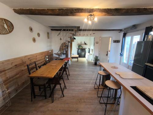 - un restaurant avec des tables et des chaises en bois dans une chambre dans l'établissement Maison de campagne en pierre à 15 min de Pau, à Jurançon